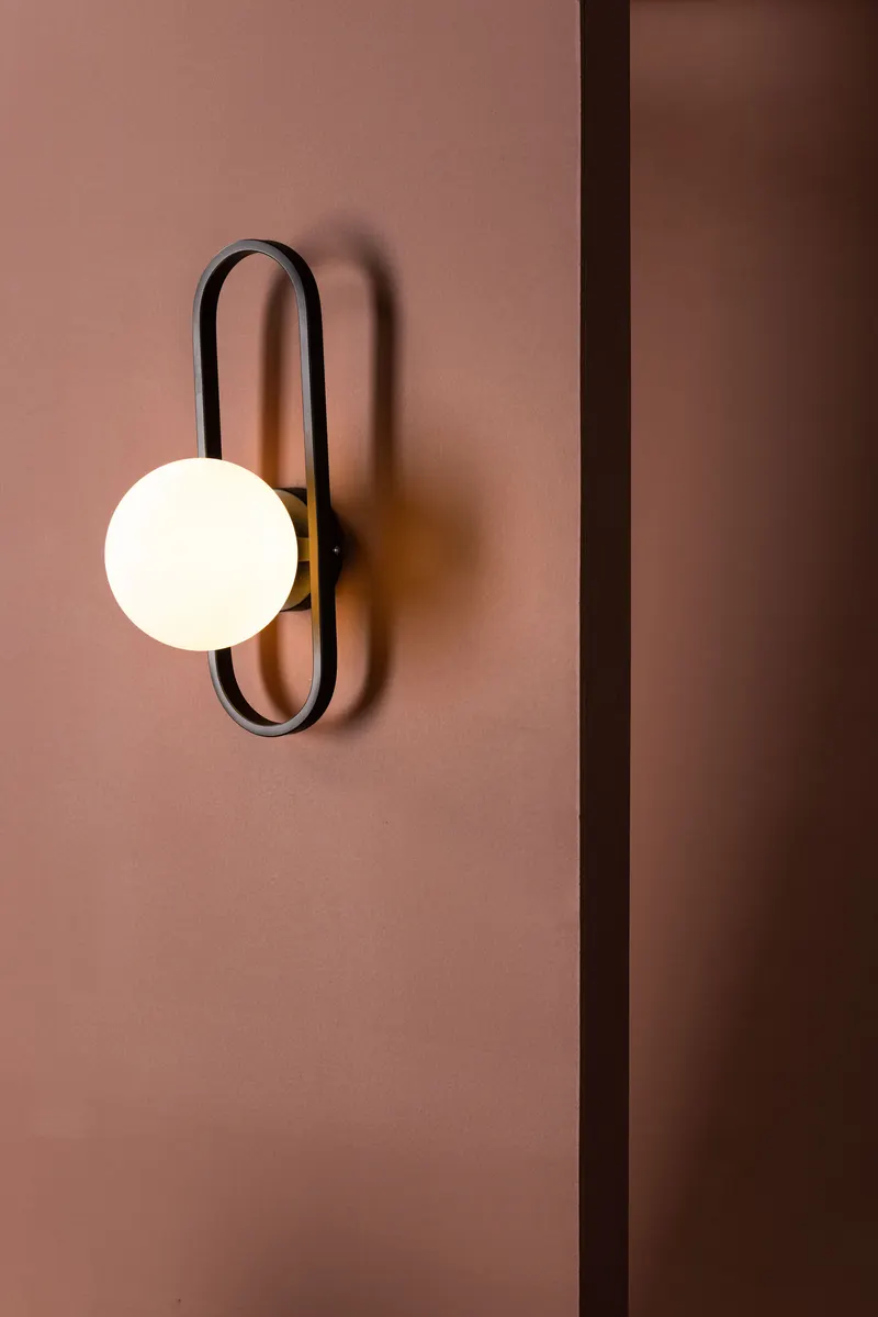 Alpes Wandleuchte mit ovalem Eisenbügel und Glaskugel, im Wohnraum, Ansicht 4