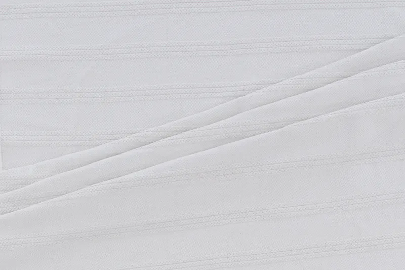Nico handgewebter Baumwollteppich mit Fransen in 230 × 160 cm, Cremeweiß, im Wohnraum, Ansicht 1