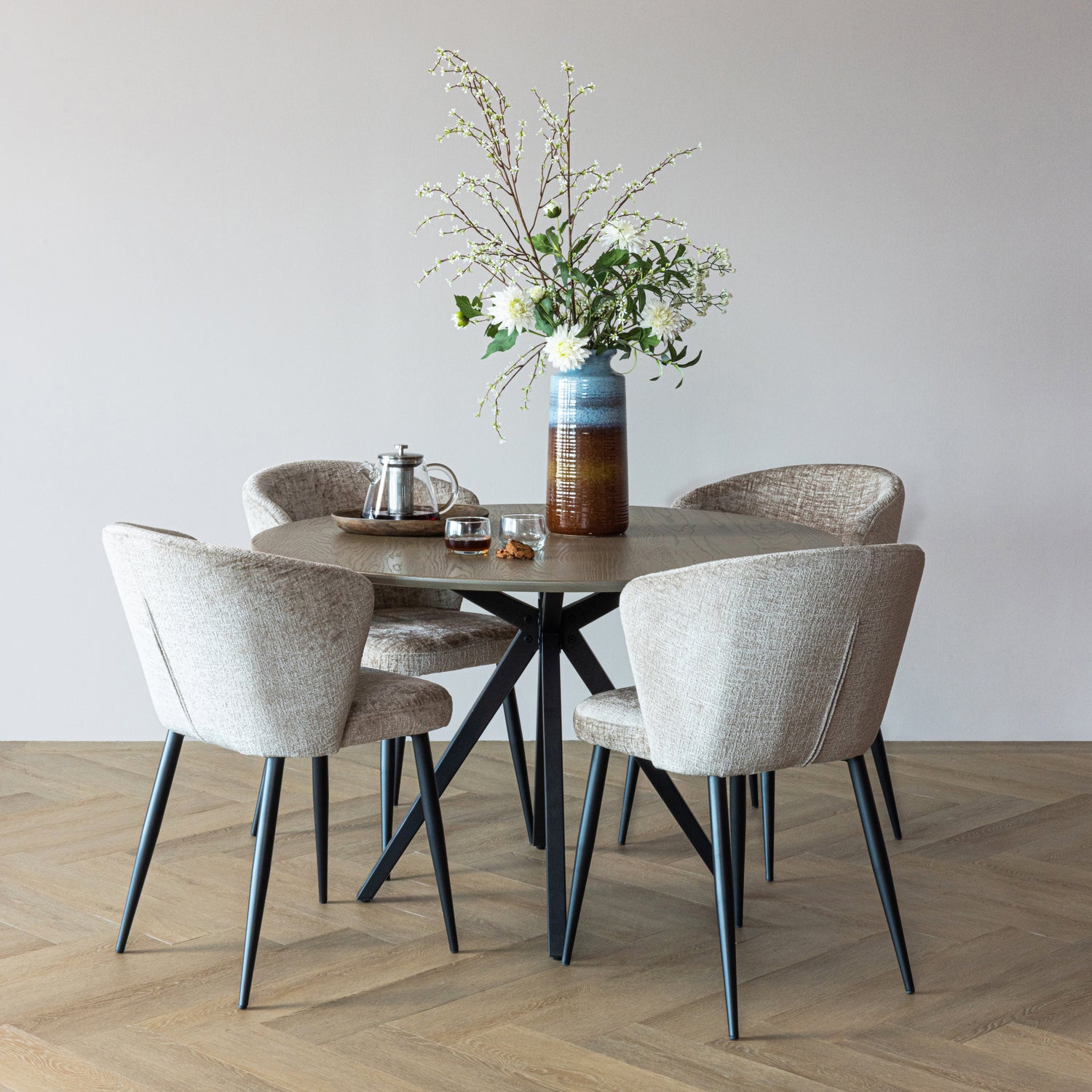 Vier Stühle Luse von WOOOD in Beige an einem runden Esstisch